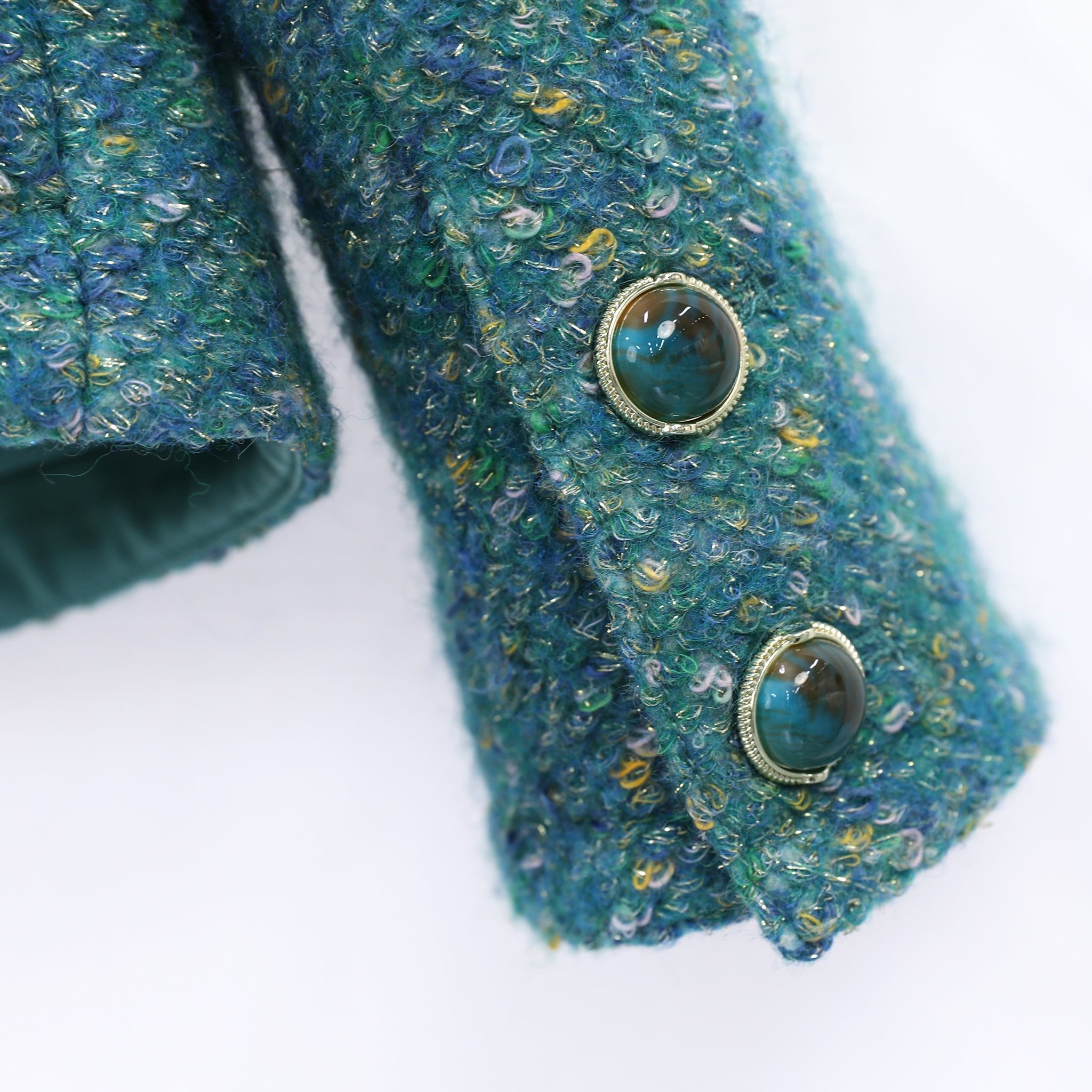 gemstone button details and fabric detials of green tweed jacket