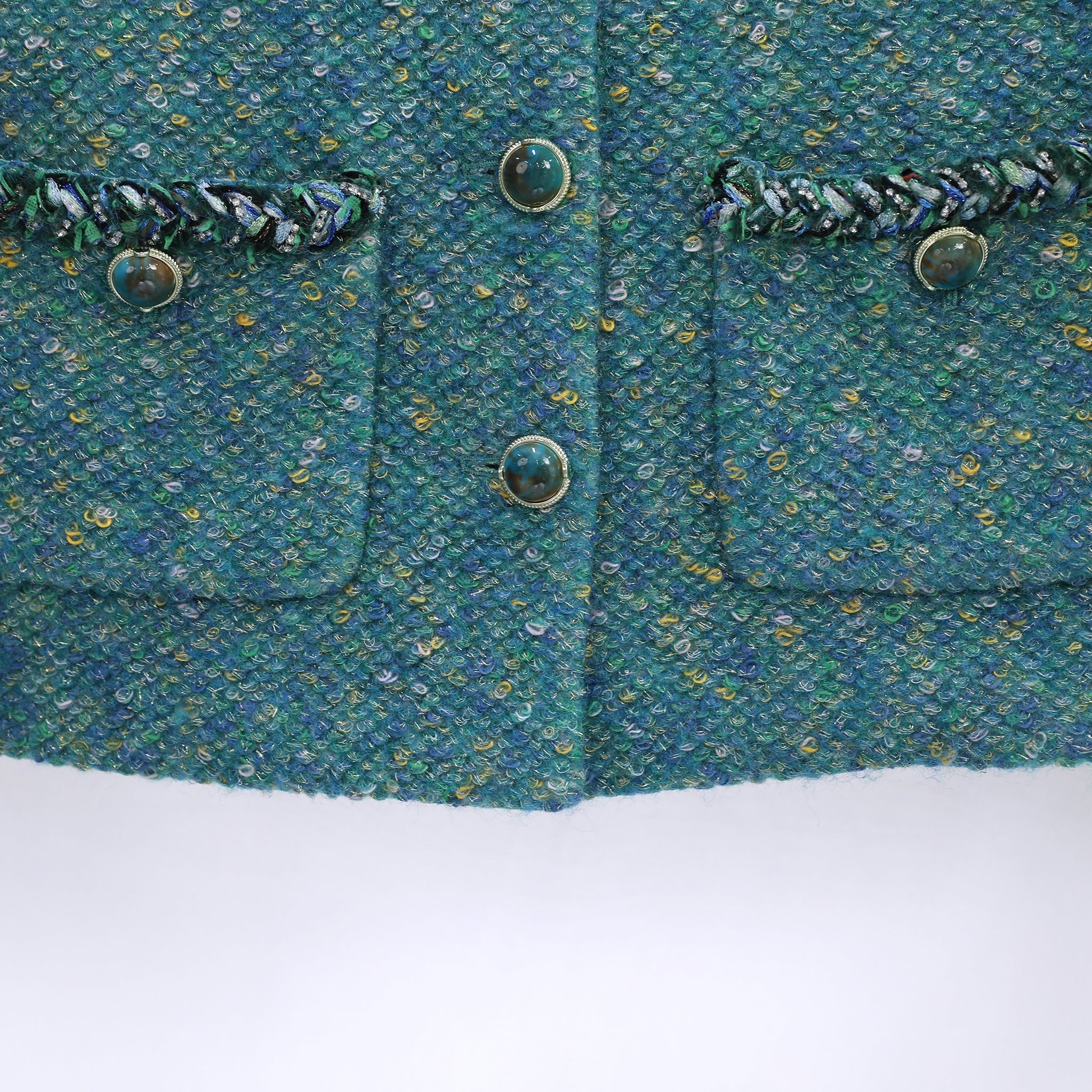 pocket details and button detials of green tweed jacket
